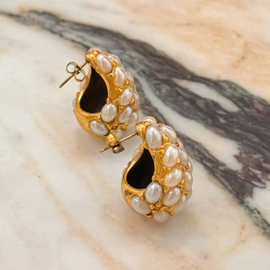 Vintage style gold hollow teardrop earrings with clusters of white pearls on marble