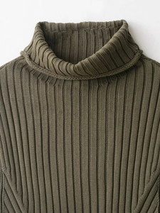 Close-up of olive green high turtleneck knit sweater featuring vertical ribbed texture