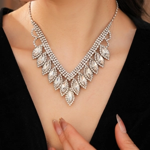 Close-up of elegant V-shaped silver necklace with marquise and round crystals on a model