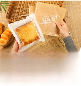 Close-up of greaseproof toast bread bags with Baking Handmade print on rattan tray