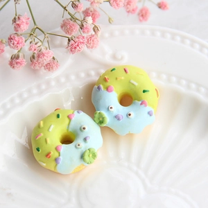 Nahaufnahme von Harz-Donut-Anhängern mit blauem Guss auf einer weißen Muschelplatte