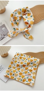 Detail of white cotton linen scarf featuring yellow heart prints and crochet lace edges