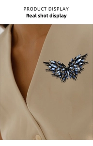 Detail of dark crystal butterfly brooch pinned on a beige blazer lapel for styling