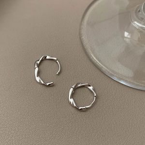 Close-up of S925 silver Mobius earrings featuring a minimalist twisted texture design