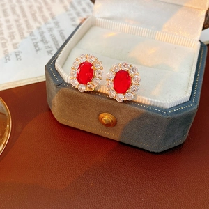 Nahaufnahme von Vintage-Ohrringen mit rotem Edelstein in einer blauen Box