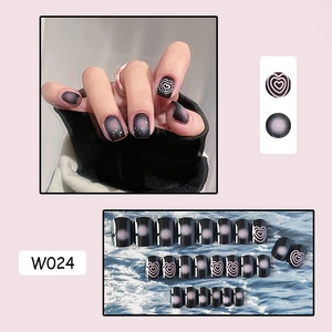 Detailed view of black and pink gradient press-on nails with white heart line designs