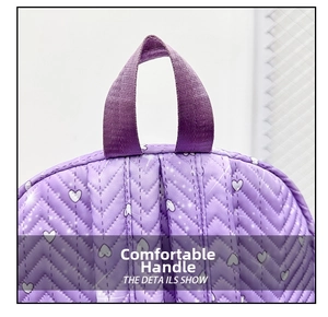 Detalle del asa de cincha púrpura reforzada y el estampado de corazones acolchados en la mochila