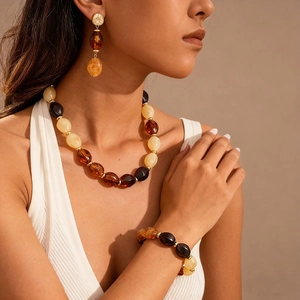 Retro resin necklace set with amber-toned oval beads and matching earrings on a model