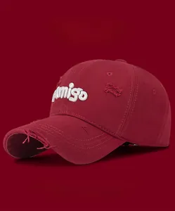 Detail of distressed burgundy cotton baseball cap with white Amigo 3D embroidery and frayed edges
