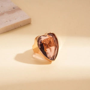 Détail d'un grand zircon cœur ambré serti sur un large anneau doré brillant poli
