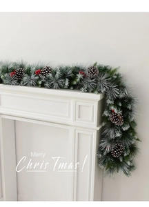 Close-up of Christmas garland with pine cones and red berries on a white fireplace mantle