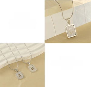 Macro detail of alphabet pendants with a sparkling crystal sand finish on snake chains
