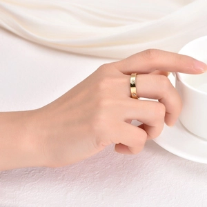 Detail shot of a gold-colored eight-pointed star ring with inlaid stones on a hand