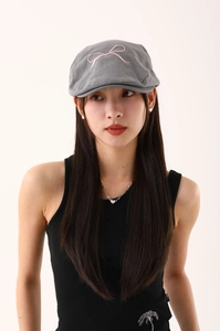 Détail d'une casquette de marin grise en coton avec broderie de nœud rose doux