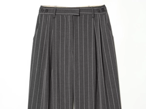 Détails du pantalon gris foncé à rayures montrant la boucle de réglage et les plis