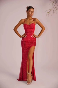 Detail of red backless halter evening gown featuring sparkling fabric and high leg slit