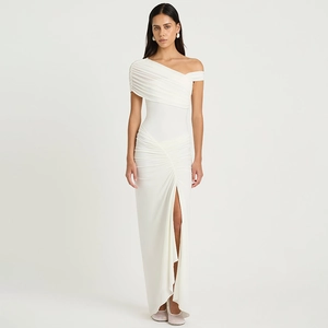 Détail de robe longue blanche élégante à une épaule avec fente latérale et tissu plissé