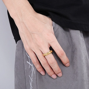 Close-up of a gold irregular wave patterned titanium ring worn on a man's finger