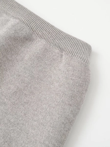 Close-up of light gray knitted fabric texture and tight ribbed edge details
