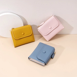 Close-up of small PU leather wallets in yellow, pink and blue with zippers and snaps