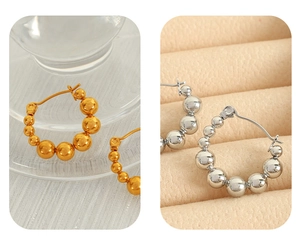 Detailed comparison of beaded hoop earrings in gold and silver finishes on jewelry stands