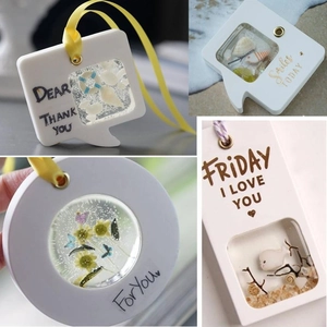 Detailed view of DIY resin mold pendants featuring sand, dried flowers and silk ribbons