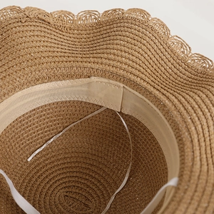 Detail of children straw sun hat showing internal sweatband and adjustable drawstring.