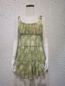 Detail shot of the tiered skirt design and floral print on the green summer dress