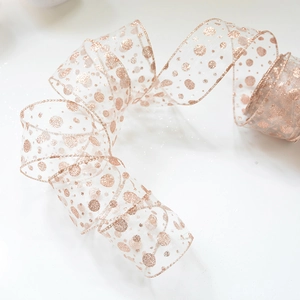 Close-up of champagne gold organza ribbon with sparkling glitter polka dot pattern