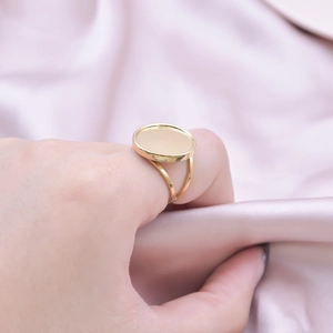 Close-up of golden geometric ring with a flat round base worn on the finger