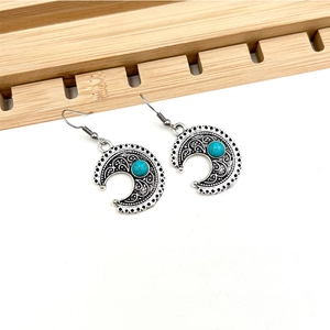 Detail view of bohemian crescent earrings with turquoise beads in vintage silver finish