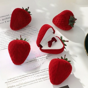 Cute strawberry-shaped flocked velvet ring box with a red bow ring inside for proposal