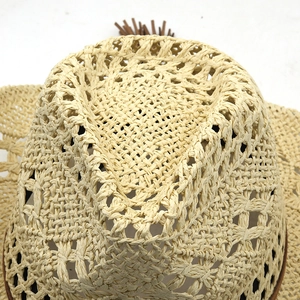 Détail d'un chapeau de paille tissé ajouré avec un gland et une texture fine