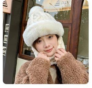 Close-up of white plush winter hood with fluffy pom-pom and thick faux rabbit fur trim