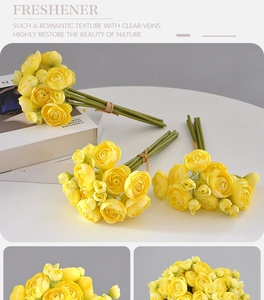 Detail of yellow silk rose wedding bouquet on white table with soft natural lighting