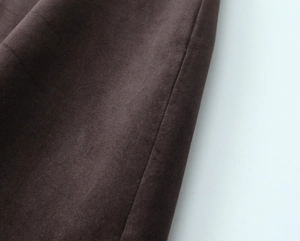 Vue rapprochée du tissu en velours côtelé marron foncé et des coutures de la robe
