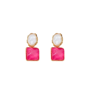 Irregular earrings with white and magenta stones in gold plated setting on white background