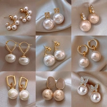 Collection of pearl earrings in gold finish featuring rhinestone and butterfly designs
