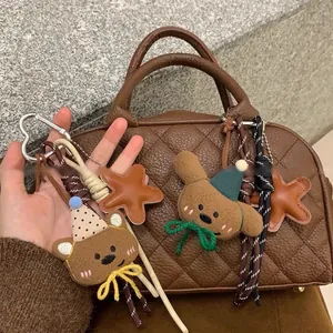 Dettaglio degli orsetti di peluche e ciondoli a stella in pelle su un portachiavi intrecciato