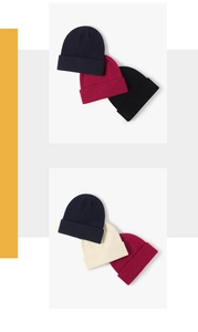 Detail of ribbed knit beanies in navy, burgundy, black, and beige colors for winter