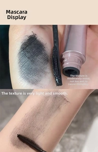 Texture display of smooth black mascara on skin with a fine spiral applicator brush