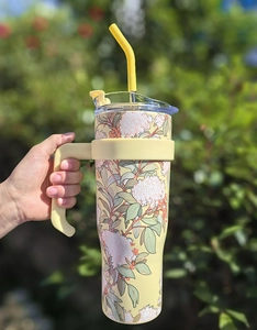 Detail of 40oz floral stainless steel tumbler with yellow handle and straw