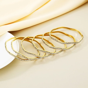 Set of 6 wavy gold-plated titanium steel bangles with sparkling micro-pave crystals