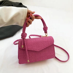 Fuchsia woven handbag with striped texture, knot detail, and gold metal hardware