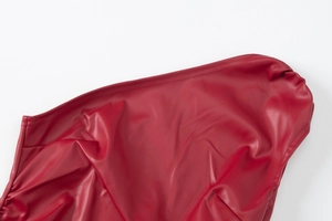 Macro shot of red PU leather vest showing detailed stitching and textured material finish