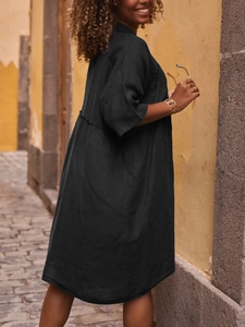 Detail of loose black cotton linen polo dress showing mid-sleeves and breezy fabric texture