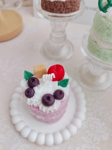 Macro detail of strawberry cake scented candle with realistic cream and fruit toppings