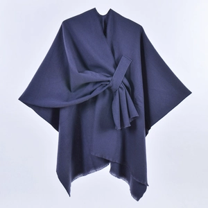 Detail of navy blue wool shawl cape featuring a stylish bow-knot tie and subtle fringe edges