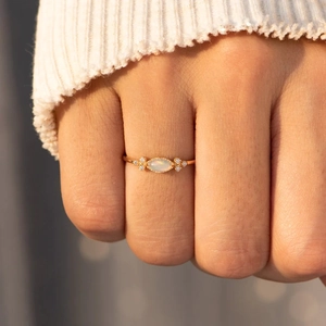 S925 Sterling Silver Marquise Opal Ring with gold finish shown on finger in warm light