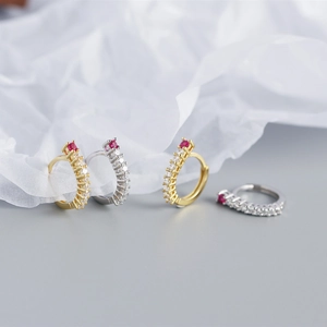 Detail of S925 sterling silver hoop earrings with small crystals and a red gemstone accent